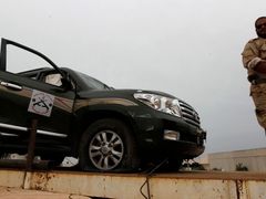 Ozbrojenec stojí v Misurátě u někdejšího Kaddáfího automobilu. U něj našel libyjský diktátor smrt.