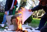 Zaměstnanci libyjské ambasády v Argentině pálí poté, co rebelové ovládli v úterý Tripolis, fotografie plukovníka Kaddáfího.