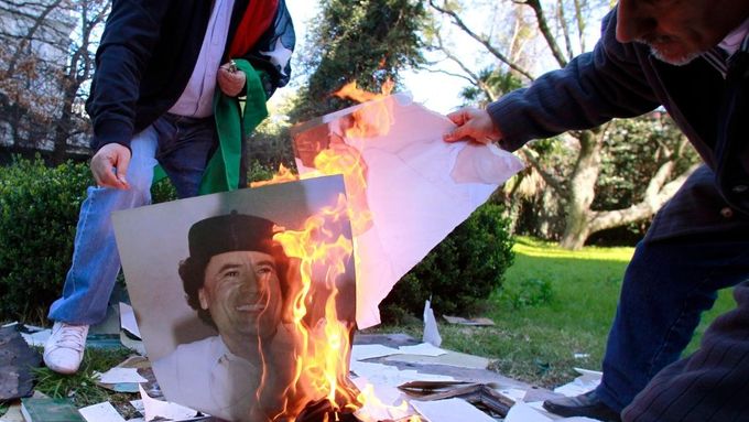 Zaměstnanci libyjské ambasády v Argentině pálí po dobytí Tripolisu rebely fotografie plukovníka Kaddáfího