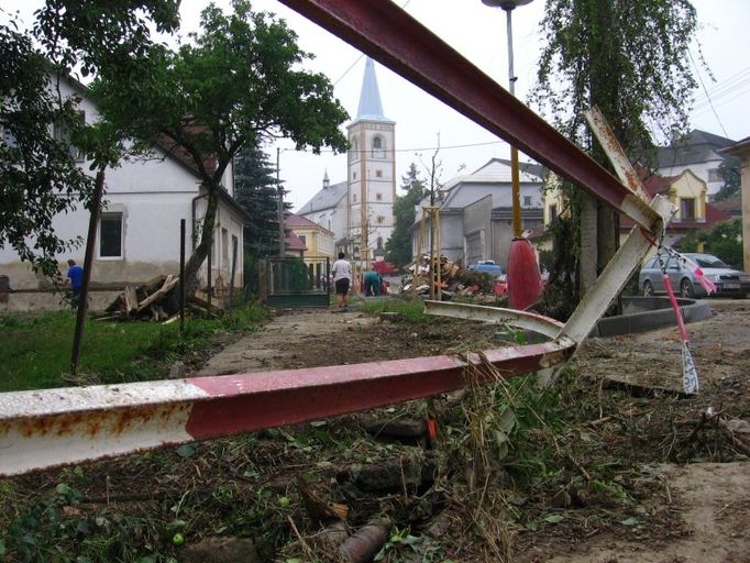 Jako válečná zóna. Zábradlí přes tenhle most voda zohýbala jako plastelínu. Jak vysoko náhlý příval ve středu kolem osmé sahal, je vidět na domě vlevo.