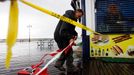 Zaměstnanec správy města New York označuje zapovězená místa řetězem vlaječek na na promenádě Coney Island.