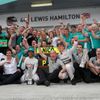 The Mercedes Formula One team celebrate outside their garage after the Malaysian F1 Grand Prix at Sepang International Circuit outside Kuala Lumpur