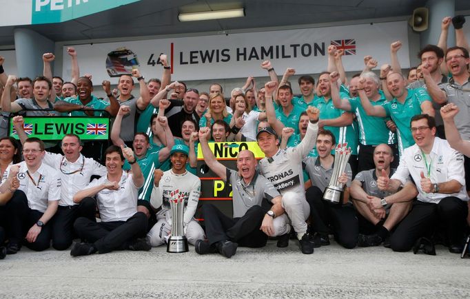 The Mercedes Formula One team celebrate outside their garage Lewis Hamilton of Britain (5th L) and Nico Rosberg of Germany (4th R) coming in first and second respectively