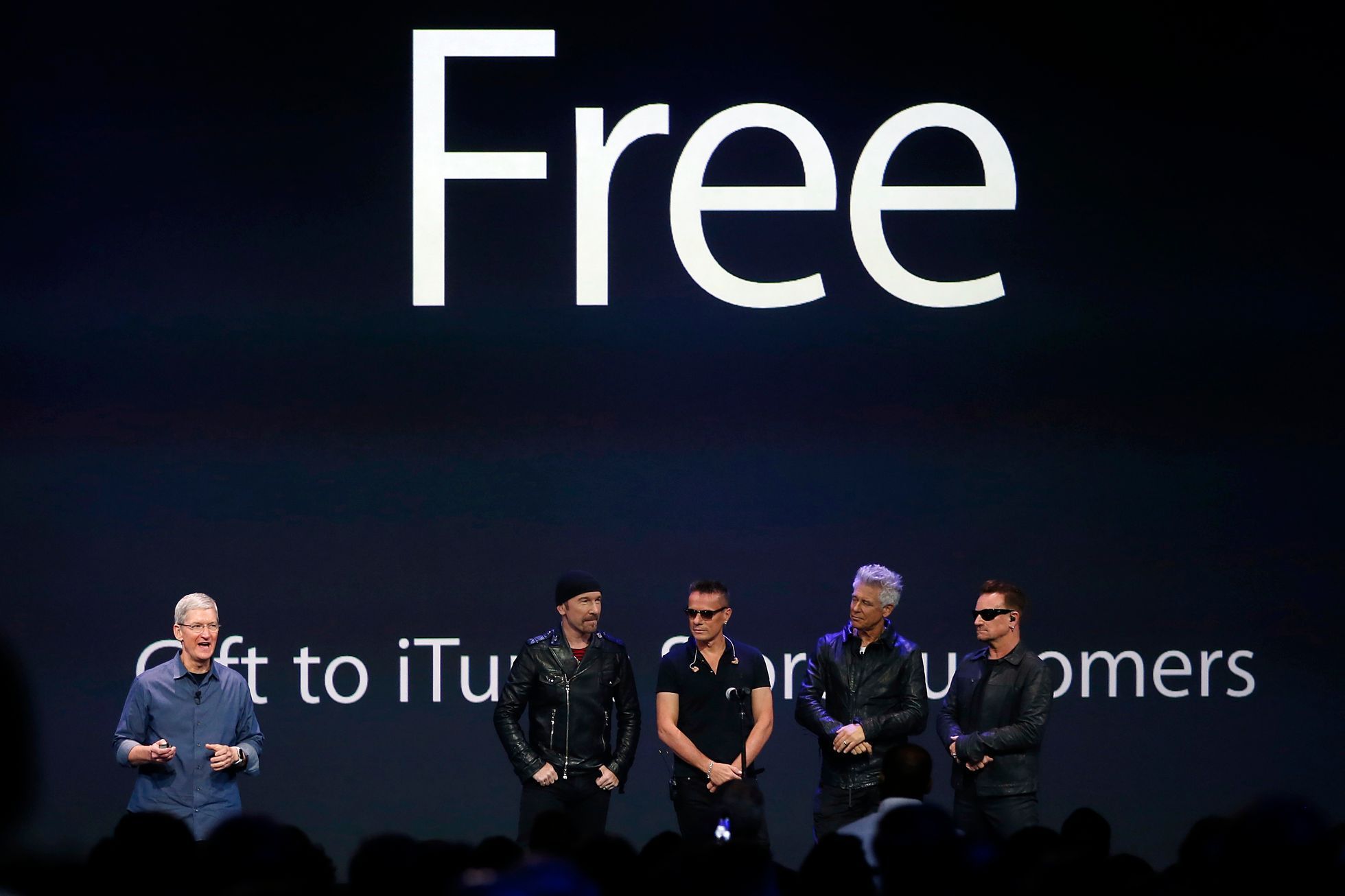 Apple CEO Tim Cook stands with Irish rock band U2 as he speaks during an Apple event announcing the iPhone 6 and the Apple Watch at the Flint Center in Cupertino