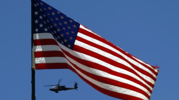 A U.S. Army Apache helicopter flies past a flag on Observation Post Mustang in Afghanistan's Kunar Province June 4, 2012. REUTERS/Tim Wimborne (AFGHANISTAN - Tags: CIVIL UNREST MILITARY CONFLICT) Published: Čer. 4, 2012, 4:52 odp.