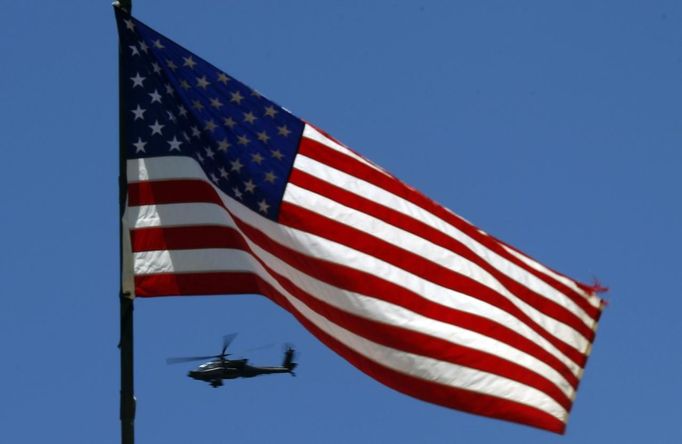 A U.S. Army Apache helicopter flies past a flag on Observation Post Mustang in Afghanistan's Kunar Province June 4, 2012. REUTERS/Tim Wimborne (AFGHANISTAN - Tags: CIVIL UNREST MILITARY CONFLICT) Published: Čer. 4, 2012, 4:52 odp.