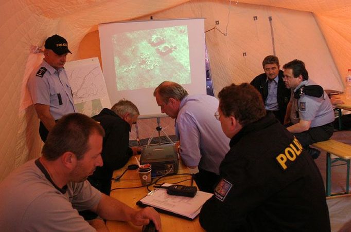 Policejním jednotkám velel štáb, který sídlil v oranžovém stanu, do nějž byly přenášeny záběry z helikoptéry kroužící nad loukou.