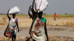 Ženy v Jižním Súdánu nesou pytle s jídlem.