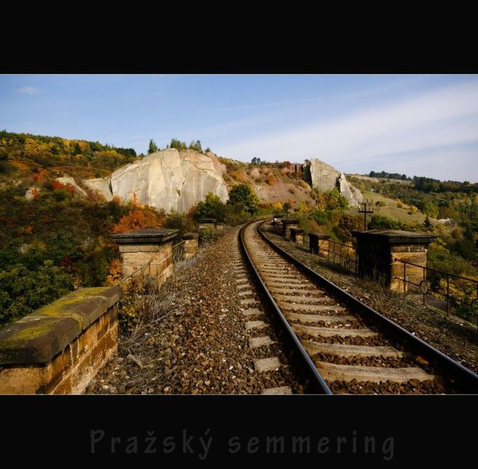 Pražský Semmering na Praze 5. Důvod výstavby této trati byl v zajištění přepravy uhlí od Kladna a dřeva od Lán do Prahy. Výstavba trati byla zahájena v červenci 1868. Vyměření trati provedl ing. Vilém Ast, výstavbu provedla firma Schön a Wesely. Celá trať z Prahy Smíchova do Hostivic měřila 19 km. Výškový rozdíl 180 m si vyžádal stavbu dvou viaduktů v Hlubočepích. První je dlouhý 115 m a 25 m vysoký, druhý je dlouhý 92 m a 22 m vysoký. Stavba mostů byla realizována v letech 1870 - 1872. Provoz na trati pro nákladní dopravu byl zahájen 3. července 1872, osobní doprava byla zahájena 16. září 1872. Dnes už není provoz na této trati tak čilý jako dříve, o čemž svědčí nevyužité zarostlé výhybny, opuštěné strážní domky a pohaslá návěstidla. Pořád si ale zachovává svůj dopravní význam a hlavně romantiku horské trati, která se vine mezi vápencovými skalami Prokopského údolí i šplhá na vysoké srázy nad Prahou.