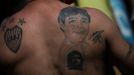 A man with a tattoo of soccer legend Diego Armando Maradona on his back poses for a picture outside the Casa Rosada presidential palace as people gather to mourn Maradona