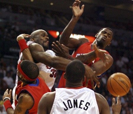 Basketbalista Miami Heat Shaquille O'Neal (v bílém vlevo) bojuje o míč s hráči Detriotu Antonio McDyessem (vpravo vzadu) a Richardem Hamiltonem (vlevo).