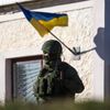 An armed man, believed to be a Russian serviceman, stands guard outside a Ukrainian military base in Perevalnoye
