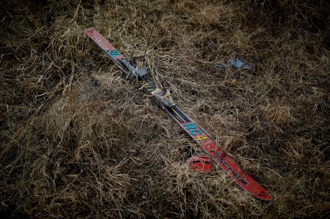 A Fischer ski lies in grass at the abandoned Alps Ski Resort