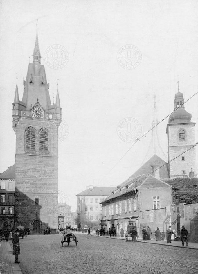 Pohled do Jindřišské ulice. Vlevo zvonice kostela sv. Jindřicha, vpravo fara čp. 973. V pozadí vpravo kostel sv. Jindřicha. Rok cca 1905