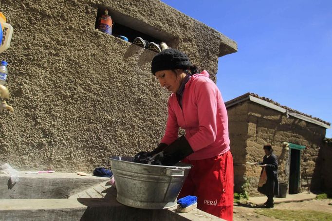 Marathon runner Gladys Tejeda, the first Peruvian athlete who qualified for the 2012 London Olympic Games, washes her clothes after training at her home in the Andean province of Junin May 14, 2012. A private company will take Gladys' mother Marcelina Pucuhuaranga, 69, to London as part of the "Thank you Mom" program. For Pucuhuaranga, who received her first passport, it will be the first time travelling out of Peru. The program will take about 120 mothers of different athletes around the world to attend the games. Tejeda, the youngest of nine children, returned to her hometown to visit her mother and to focus on training where she will run more than 20 km every day in the highlands (over 4,105 meters above sea level). Picture taken May 14, 2012. REUTERS/Pilar Olivares (PERU - Tags: SPORT ATHLETICS OLYMPICS) Published: Kvě. 17, 2012, 6:57 odp.