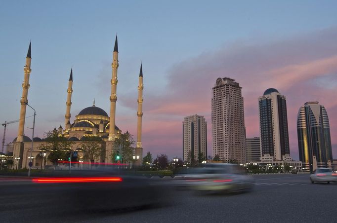 Cars drive along Akhmad Kadyrov Avenue, with the Heart of Chechnya mosque and skyscrapers in the background in the Chechen capital Grozny April 27, 2013. The naming of two Chechens, Dzhokhar and Tamerlan Tsarnaev, as suspects in the Boston Marathon bombings has put Chechnya - the former site of a bloody separatist insurgency - back on the world's front pages. Chechnya appears almost miraculously reborn. The streets have been rebuilt. Walls riddled with bullet holes are long gone. New high rise buildings soar into the sky. Spotless playgrounds are packed with children. A giant marble mosque glimmers in the night.Yet, scratch the surface and the miracle is less impressive than it seems. Behind closed doors, people speak of a warped and oppressive place, run by a Kremlin-imposed leader through fear. Picture taken April 27, 2013. REUTERS/Maxim Shemetov (RUSSIA - Tags: SOCIETY POLITICS RELIGION TRANSPORT) ATTENTION EDITORS: PICTURE 03 OF 40 FOR PACKAGE 'INSIDE MODERN CHECHNYA'. SEARCH 'REBUILDING CHECHNYA' FOR ALL IMAGES Published: Kvě. 1, 2013, 7:16 dop.