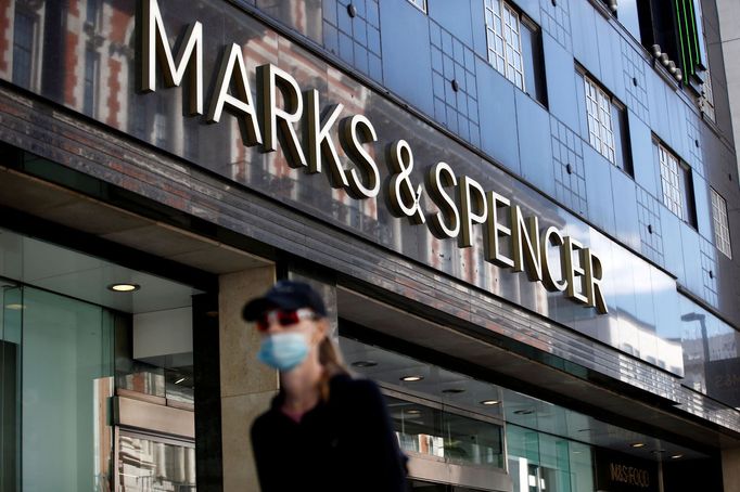 Žena v roušce míjí obchod britské značky Marks & Spencer v Londýně.