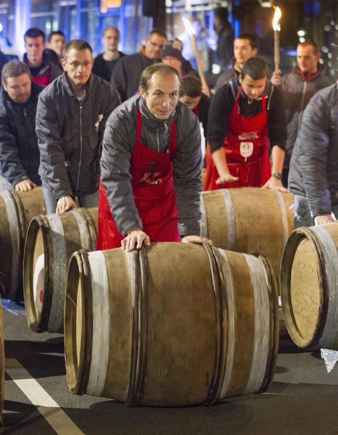 Men roll barrels of Beaujolais Nouveau wine for the official launch of the 2012 vintage in the center of Lyon early November 15, 2012. REUTERS/Robert Pratta (FRANCE - Tags: SOCIETY) Published: Lis. 15, 2012, 2:13 dop.