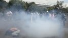 Members of the media film a supporter of a native Indian community living at the Brazilian Indian Museum as she lies amid tear gas during clashes with military police officers as they protest against the community's eviction in Rio de Janeiro March 22, 2013. Brazilian military police took position early morning outside the abandoned museum, where the community of around 30 native Indians have been living in since 2006. The community was ordered to leave the museum in 72 hours by court officials since last week, local media reported. Most of the Indians later left the museum after making a deal with the authorities. REUTERS/Ricardo Moraes (BRAZIL - Tags: MEDIA CIVIL UNREST POLITICS SOCIETY REAL ESTATE BUSINESS) Published: Bře. 22, 2013, 5:04 odp.