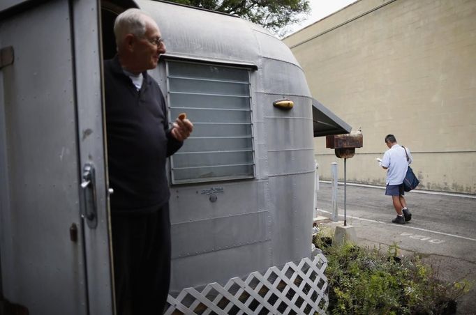 Bill Niederberger, 81, watches the mailman from his trailer in which he has lived for over 30 years, in Village Trailer Park in Santa Monica, California, July 12, 2012. Developer Marc Luzzatto wants to relocate residents from the trailer park to make way for nearly 500 residences, office space, stores, cafes and yoga studios, close to where a light rail line is being built to connect downtown Los Angeles to the ocean. Village Trailer Park was built in 1951, and 90 percent of its residents are elderly, disabled or both, according to the Legal Aid Society. Many have lived there for decades in old trailers which they bought. The property is valued at as much as $30 million, according the LA Times. Picture taken July 12, 2012. REUTERS/Lucy Nicholson (UNITED STATES - Tags: SOCIETY REAL ESTATE BUSINESS POLITICS) Published: Čec. 14, 2012, 7:20 dop.