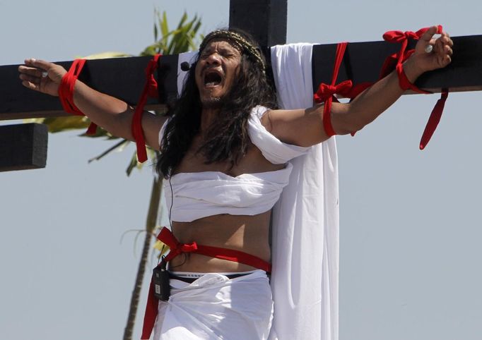 Ruben Enaje, 52, who is portraying Jesus Christ for the 27th time, screams as he hangs on a wooden cross during a Good Friday crucifixion re-enactment in San Pedro Cutud town, Pampanga province, north of Manila March 29, 2013. The Roman Catholic church frowns on the gory spectacle held in the Philippine village of Cutud every Good Friday but does nothing to deter the faithful from emulating the suffering of Christ and taking a painful route to penitence. Holy Week is celebrated in many Christian traditions during the week before Easter. REUTERS/Romeo Ranoco (PHILIPPINES - Tags: RELIGION SOCIETY) Published: Bře. 29, 2013, 8:38 dop.