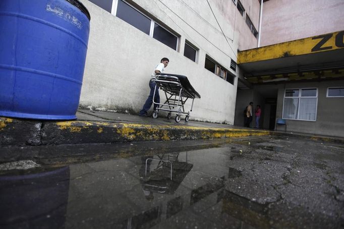 A man pushes a stretcher after taking a body to the morgue of a local hospital in San Pedro Sula March 27, 2013. San Pedro Sula, the country's second largest city after Tegucigalpa, has a homicide rate of 169 per 100,000 people and was named the world's most violent city for a second year in a row. Lax laws allow civilians to own up to five personal guns. Arms trafficking has flooded the country with nearly 70% illegal firearms. 83.4% of homicides are by firearms, compared to 60% in the United States. Picture taken March 27, 2013. REUTERS/Jorge Cabrera (HONDURAS - Tags: CRIME LAW CIVIL UNREST HEALTH) ATTENTION EDITORS: PICTURE 14 OF 39 FOR PACKAGE 'GUN CULTURE - HONDURAS' SEARCH 'HONDURAS GUN' FOR ALL IMAGES Published: Dub. 5, 2013, 11:14 dop.