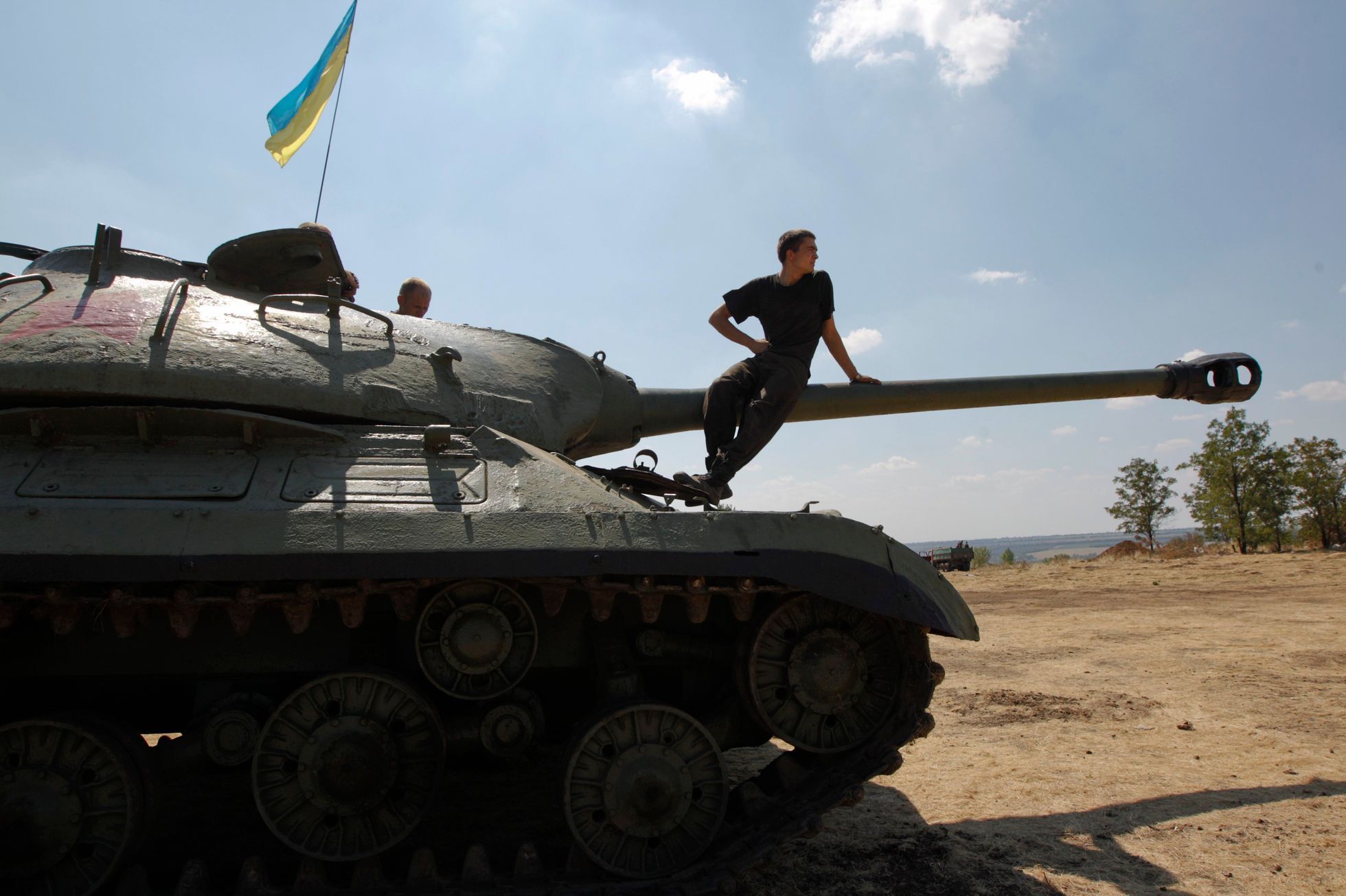 Ukrajinský voják sedí na tanku, který armáda ukořistila proruským separatistům.