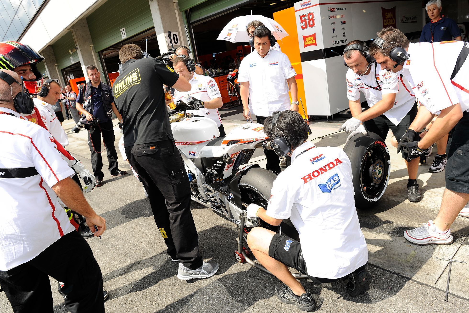 Motocykloví mechanici opravují stroj Marca Simoncelliho na GP České republiky v Brně 2011.