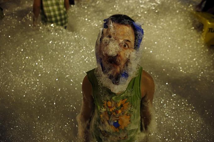 A girl poses with a picture of Spanish Prime Minister Mariano Rajoy on her face as she plays with foam thrown by firefighters during a protest against government austerity measures in Madrid July 19, 2012. A protest movement against the centre-right Spanish government's latest austerity measures swelled on Thursday as public sector workers stepped up demonstrations in Madrid and around the country after more than a week of spontaneous action. REUTERS/Susana Vera (SPAIN - Tags: CIVIL UNREST BUSINESS POLITICS TPX IMAGES OF THE DAY)