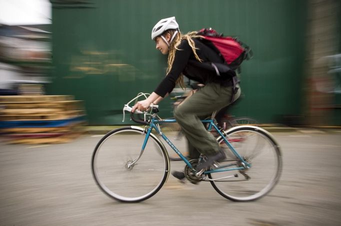 Robin Pickell, 23, a 'freegan', rides her bike to different dumpsters to find edible food in an alley behind Commercial Drive in Vancouver, British Columbia April 10, 2012. A 'Freegan' is someone who gathers edible food from the garbage bins of grocery stores or food stands that would otherwise have been thrown away. Freegans aim to spend little or no money purchasing food and other goods, not through financial need but to try to address issues of over-consumption and excess. Picture taken April 10, 2012. REUTERS/Ben Nelms (CANADA - Tags: SOCIETY) ATTENTION EDITORS PICTURE 06 OF 21 FOR PACKAGE 'DUMPSTER DIVING FOR FOOD' Published: Kvě. 15, 2012, 11:58 dop.