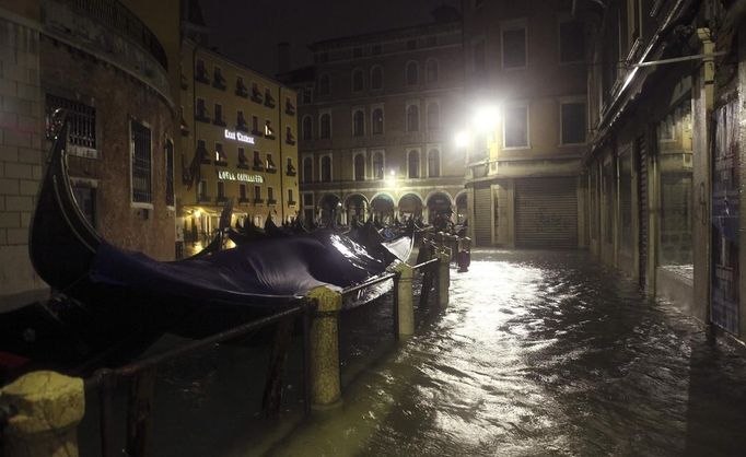 Gondolas are seen near a flooded St Mark's Square at night during a period of seasonal high water in Venice November 1, 2012. The water level in the canal city rose to 140 cm (55 inches) above normal, according to the monitoring institute. REUTERS/Manuel Silvestri (ITALY - Tags: ENVIRONMENT SOCIETY TRAVEL DISASTER TRANSPORT) Published: Lis. 1, 2012, 8:15 dop.