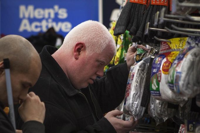 David Givens (R), a visually impaired albino student from the World Services for the Blind (WSB), pulls a package of socks close to his eyes while shopping at a department store in Little Rock, Arkansas January 5, 2013. Albinism is a group of genetic conditions that causes a lack of melanin pigment in the eyes or both in the eyes and in the skin. Standing on the left is visually impaired student Miguel Mendez. The WSB is a rehabilitation center for the blind or visually impaired which offers life skills and career training programs designed to help those enrolled achieve sustainable independence. Picture taken on January 5, 2013. REUTERS/Gaia Squarci (UNITED STATES - Tags: HEALTH EDUCATION SOCIETY) Published: Dub. 26, 2013, 2:16 odp.