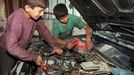 deux jeunes enfants palestiniens travaillent dans un garage de Jerusalem est le 30 octobre 1997. Two Palestinian children repair a car engine in a garage in East Jerusalem, 30 October. The International Labour Organisation has warned of increasing child labour in the West Bank and Gaza, saying some seven percent of Palestinian children work, often long hours in dangerous conditions.