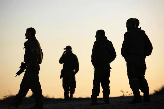 Israeli soldiers stand at their base just outside the central Gaza Strip November 15, 2012. A Hamas rocket killed three Israelis north of the Gaza Strip on Thursday, drawing the first blood from Israel as the Palestinian death toll rose to 15 in a military showdown lurching closer to all-out war and an invasion of the enclave. REUTERS/Amir Cohen (ISRAEL - Tags: POLITICS CIVIL UNREST) Published: Lis. 15, 2012, 4:41 odp.