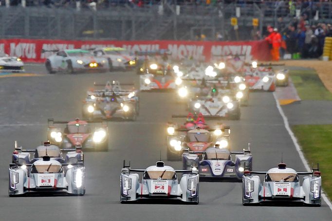 The Audi R18 E-Tron Quattro drivers Andre Lotterer of Germany (1), Britain Allan McNish (2) and Lucas Di Grassi of Brazil (3) drive just ahead of the Toyota TS030 Hybrid