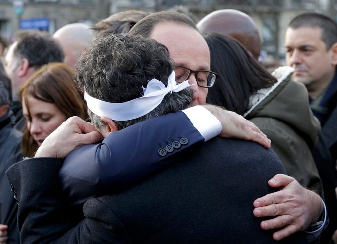 Prezident Francois Hollande objímá sloupkaře týdeníku Charlie Hebdo Patricka Pellouxe na pochodu národní jednoty.