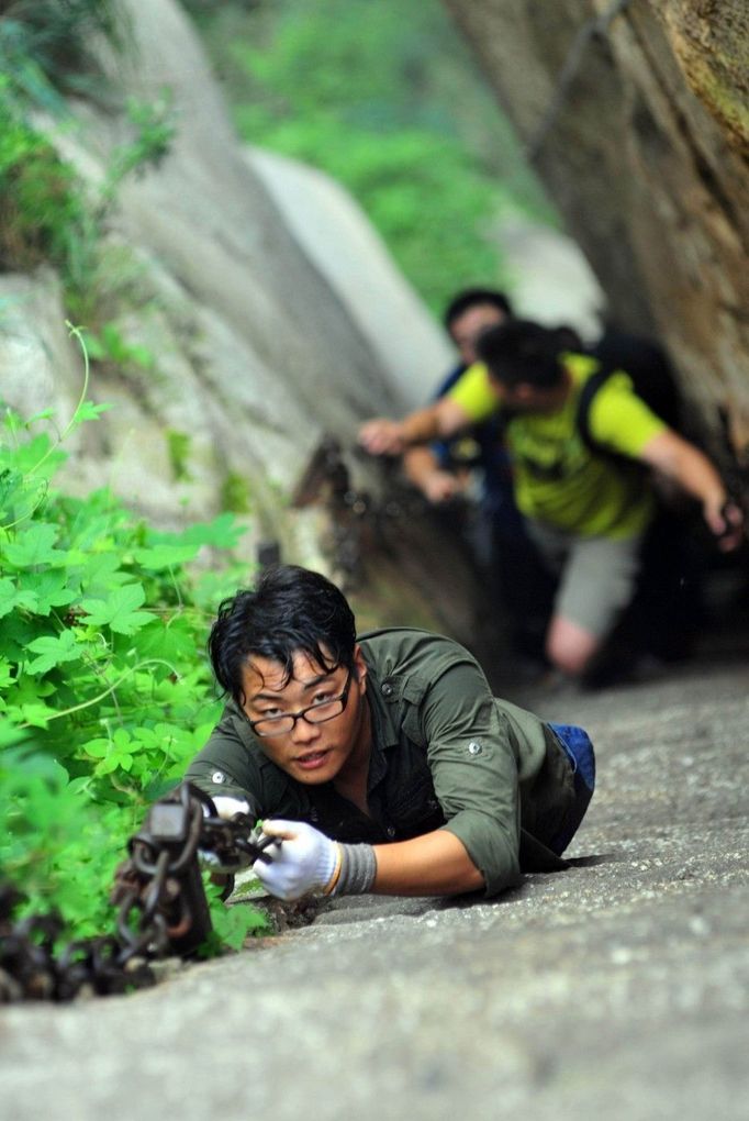 HUAYIN, CHINA - AUGUST 13: (CHINA OUT) Legless man Chen Zhou climbs the Huashan Mountain on August 13, 2012 in Huayin, Shaanxi Province of China. Legless 29-year-old man Chen Zhou from Cangshan of Shandong Province spent two days, 19 hours in total, climbing by arms to the top of Huashan Mountain. Chen lost his legs after falling off a train at the age of 13, but he has since strived to be stronger and joined in many public performances to encourage other people. Chen Zhou will climb the Taishan Mountain in Shandong province in the following months. ( automatický překlad do češtiny )