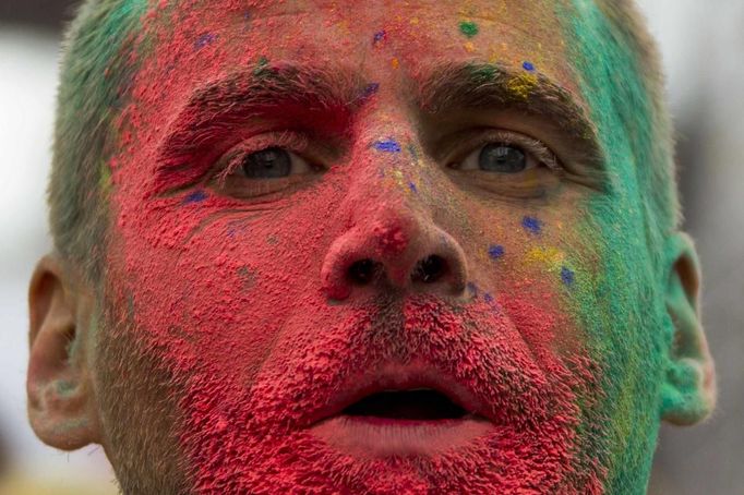 A reveller's face is covered in pigment powder during the Holi festival in Berlin, July 29, 2012. Holi, also known as the festival of colours, is a festival celebrated in India and other Hindu countries that in its original form heralds the beginning of spring. The Berlin event brought Indian Djs, acrobatics and dance to the German capital. REUTERS/Thomas Peter (GERMANY - Tags: SOCIETY) Published: Čec. 29, 2012, 4:14 odp.