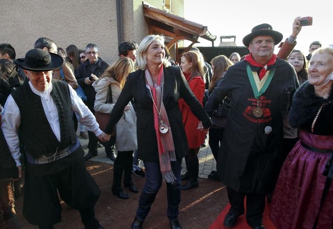 France's National Front leader Marine Le Pen (C) attends a ceremony in a Beaujolais vineyard brotherhood at Domaine des Maisons Neuves during a visit in Blace, November 14, 2012. REUTERS/Robert Pratta (FRANCE - Tags: POLITICS FOOD) Published: Lis. 14, 2012, 4:33 odp.