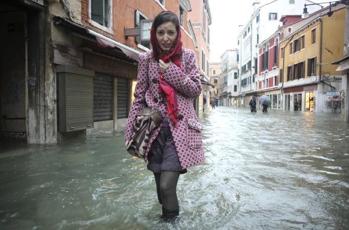 A woman walks in a flooded street during a period of seasonal high water in Venice November 11, 2012. The water level in the canal city rose to 149 cm (59 inches) above normal, according to local monitoring institute Center Weather Warnings and Tides. REUTERS/Manuel Silvestri (ITALY - Tags: ENVIRONMENT SOCIETY) Published: Lis. 11, 2012, 1:54 odp.