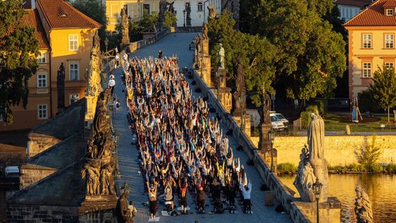 Pozdrav slunci na Karlově mostě. Čtyři stovky lidí ráno cvičily v centru Prahy jógu