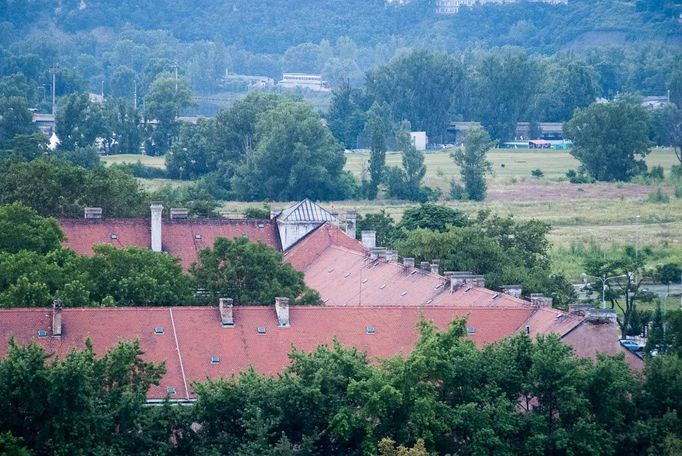 Čtvercová stavba Invalidovny disponuje masivní střechou a uprostřed je dvůr zarostlý zelení.