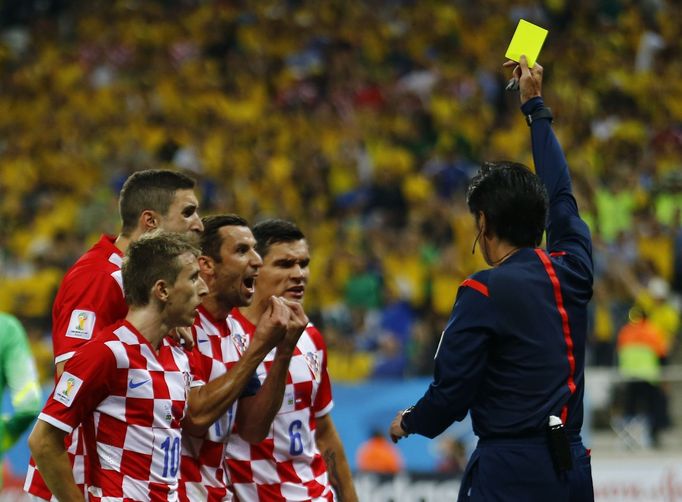 Referee Yuichi Nishimura (R) of Japan shows the yellow card to Croatia's Dejan Lovren (2nd R), for a foul on Brazil's Fred (unseen), during the 2014 World Cup opening mat