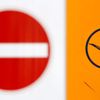 Traffic sign is seen next to logo of Lufthansa at Munich's airport