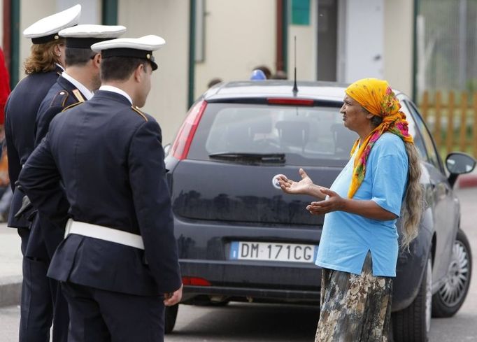 A woman speaks with Italian municipal police officers at an authorised Roma camp, after about 50 men were taken away during an overnight police raid in Rome May 15, 2008. Italian police arrested hundreds of suspected illegal immigrants on Thursday in a sign of the new right-wing government's determination to clamp down. Some of those held in the operation, which stretched from northern Italy to the Campania region around Naples, were ordered to be immediately expelled. REUTERS/Chris Helgren (ITALY)