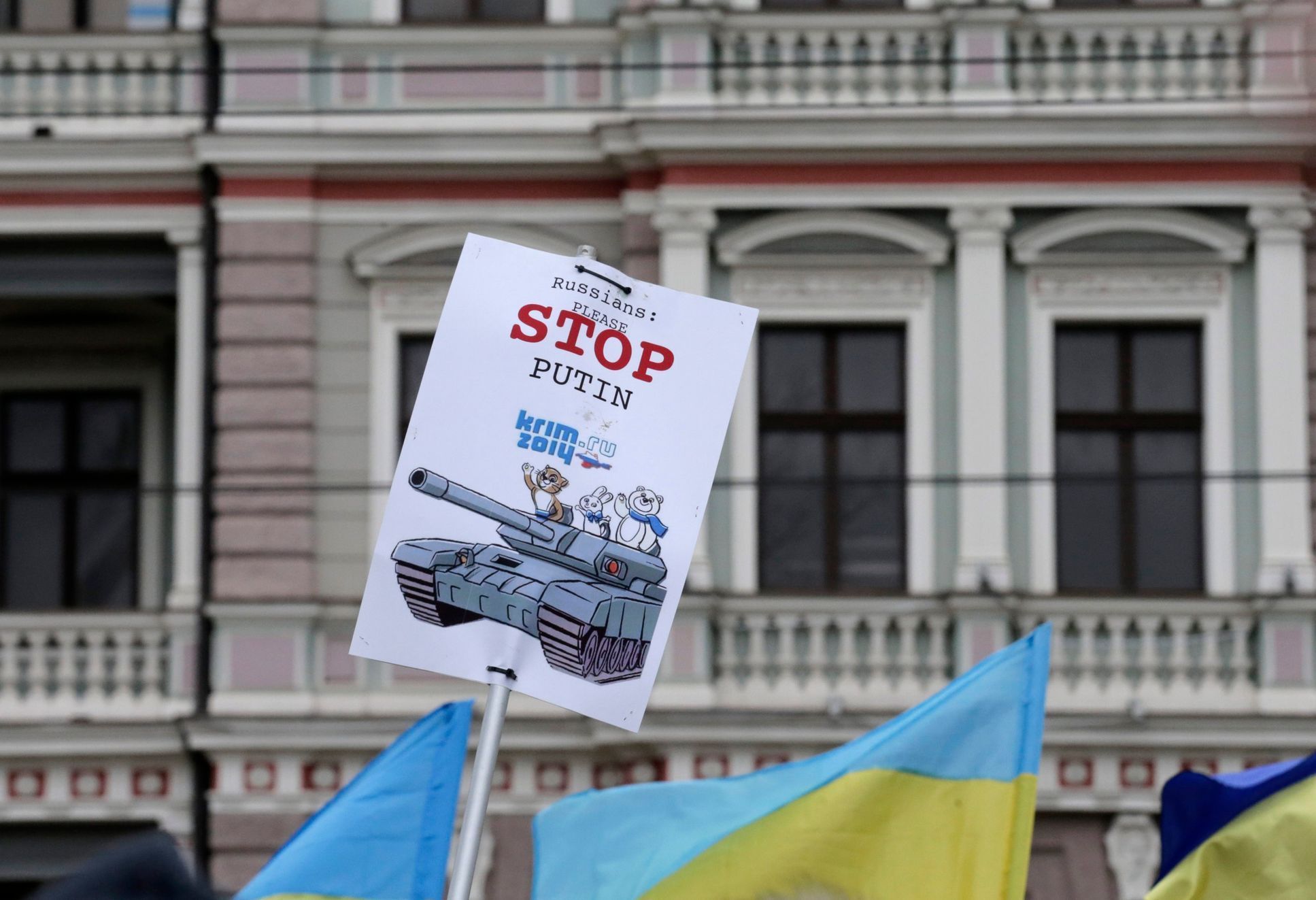 Ukraine's flags and a poster are pictured in front of Russia's embassy during a protest rally against Russian intervention in Crimea, in Riga