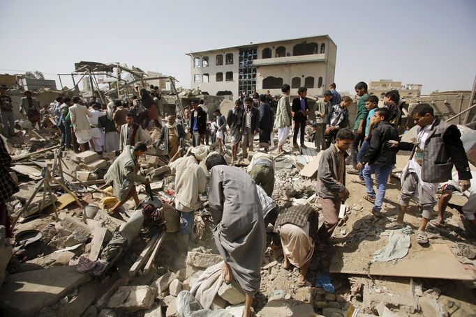 Vendors and people salvage goods from under the rubble of shops destroyed by a Saudi-led air strike that hit a marketplace in Yemen's capital Sanaa July 20, 2015.