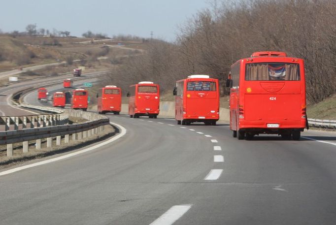 Na Bělehrad! Červené autobusy cestovní kanceláře z Niše vezou demonstranty do hlavního města.