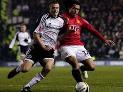 Carlos Tevez v souboji s fotbalistou Derby County Paulem Connollym v semifinále Carling Cupu.