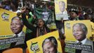 People hold placards of former South African President Nelson Mandela at the First National Bank (FNB) Stadium, also known as Soccer City, during the national memorial service for Mandela in Johannesburg December 10, 2013.